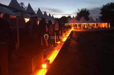 Salle équipée de plusieurs écrans, éclairages bleus et matériel audiovisuel, prête pour un événement ou une présentation.