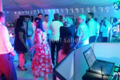 Groupe de personnes dansant sous des lumières colorées dans une salle avec un plafond industriel.