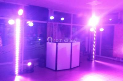 Groupe de personnes dansant sous des lumières colorées dans une salle avec un plafond industriel.