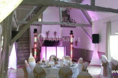 Groupe de personnes dansant sous des lumières colorées dans une salle avec un plafond industriel.
