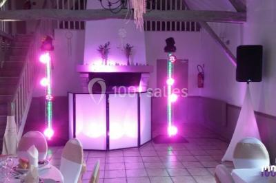 Groupe de personnes dansant sous des lumières colorées dans une salle avec un plafond industriel.