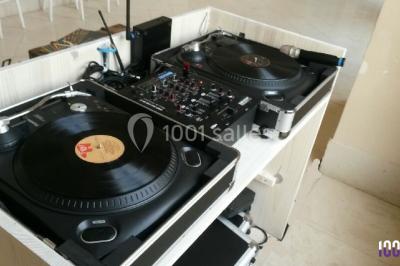 Groupe de personnes dansant sous des lumières colorées dans une salle avec un plafond industriel.