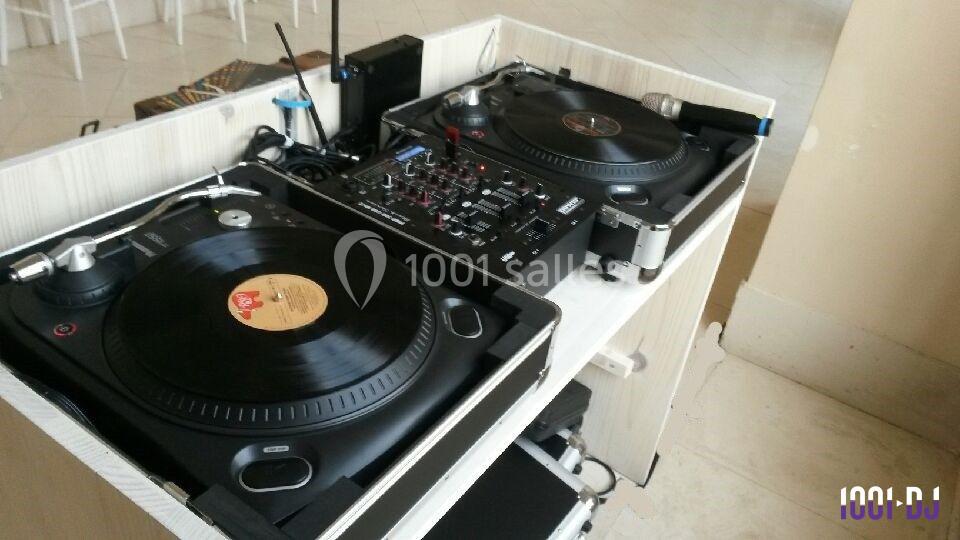 Deux platines vinyles et une table de mixage installées sur un meuble dans un espace intérieur lumineux.