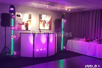 Groupe de personnes dansant sous des lumières colorées dans une salle avec un plafond industriel.