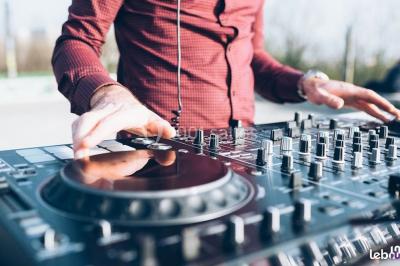 Groupe de personnes dansant sous des lumières colorées dans une salle avec un plafond industriel.