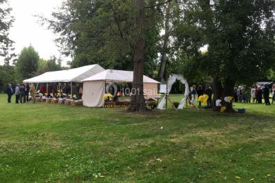 Groupe de personnes dans une salle éclairée par des lumières roses, certaines tenant des bougies.