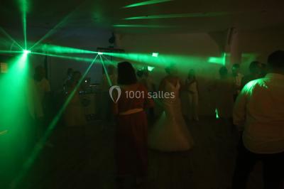 Groupe de personnes dans une salle éclairée par des lumières roses, certaines tenant des bougies.