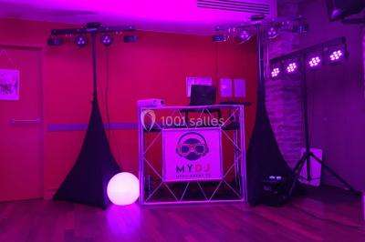 Groupe de personnes dans une salle éclairée par des lumières roses, certaines tenant des bougies.