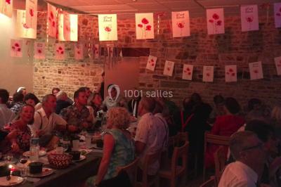 Groupe de personnes dans une salle éclairée par des lumières roses, certaines tenant des bougies.