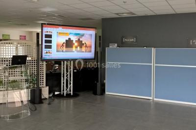 Groupe de personnes dans une salle éclairée par des lumières roses, certaines tenant des bougies.
