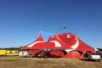 Groupe de personnes dans une salle éclairée par des lumières roses, certaines tenant des bougies.