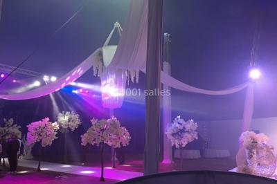 Groupe de personnes dans une salle éclairée par des lumières roses, certaines tenant des bougies.