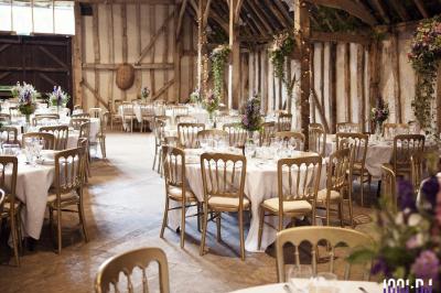Un couple en tenue de mariage pose devant des lumières colorées dans une ambiance festive.