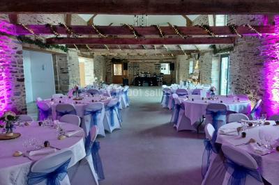 Un couple en tenue de mariage pose devant des lumières colorées dans une ambiance festive.