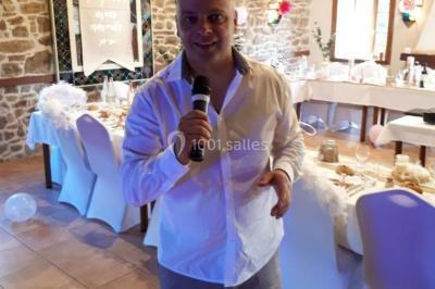 Un couple en tenue de mariage pose devant des lumières colorées dans une ambiance festive.