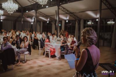Un couple en tenue de mariage pose devant des lumières colorées dans une ambiance festive.