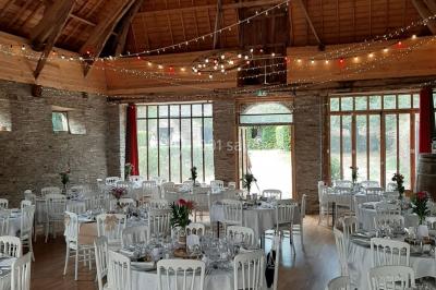 Un couple en tenue de mariage pose devant des lumières colorées dans une ambiance festive.