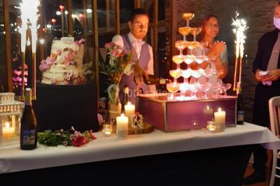 Un couple en tenue de mariage pose devant des lumières colorées dans une ambiance festive.
