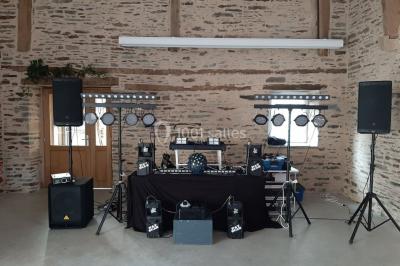 Un couple en tenue de mariage pose devant des lumières colorées dans une ambiance festive.