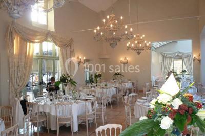 Ruelle pavée bordée de fleurs, avec un puits en pierre et des bâtiments anciens sous un ciel ensoleillé.