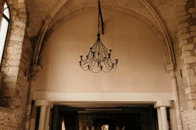 Ruelle pavée bordée de fleurs, avec un puits en pierre et des bâtiments anciens sous un ciel ensoleillé.