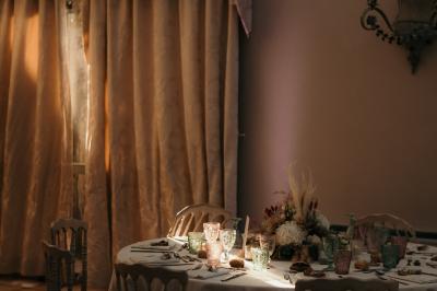 Ruelle pavée bordée de fleurs, avec un puits en pierre et des bâtiments anciens sous un ciel ensoleillé.