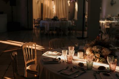 Ruelle pavée bordée de fleurs, avec un puits en pierre et des bâtiments anciens sous un ciel ensoleillé.
