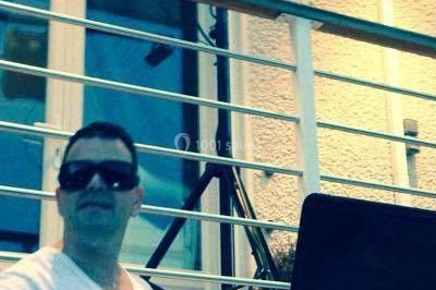 Un homme portant un casque audio mixe de la musique sur un ordinateur portable et un équipement de DJ.