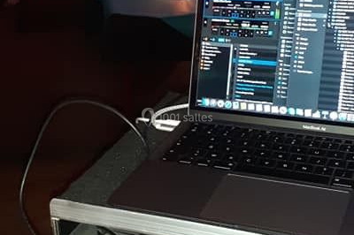 Un homme portant un casque audio mixe de la musique sur un ordinateur portable et un équipement de DJ.