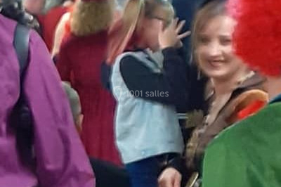 Vue d'une soirée avec un DJ en arrière-plan, des invités dans une ambiance tamisée et un écran de mixage au premier plan.