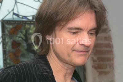 Des personnes dansent sous des guirlandes lumineuses dans une salle décorée pour une fête.