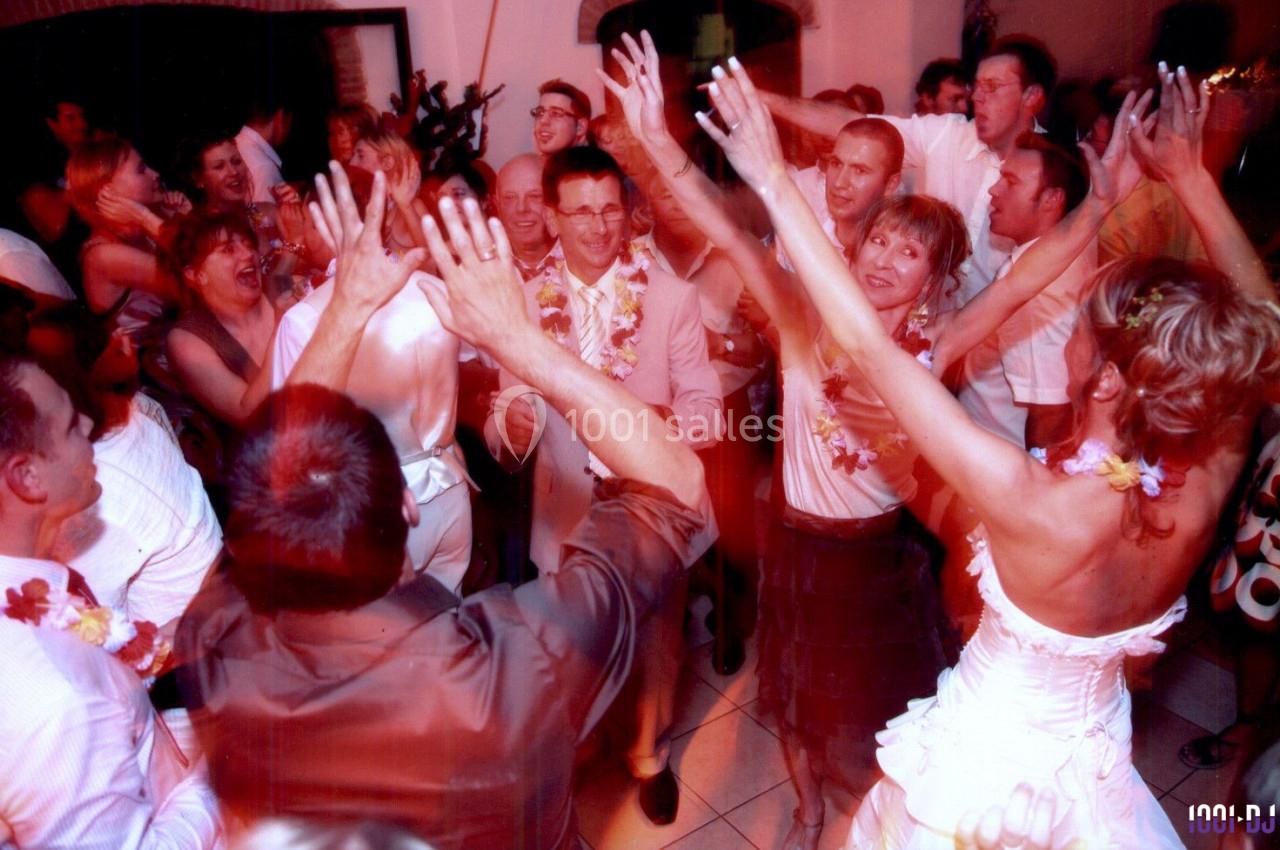 Groupe de personnes dansant et célébrant dans une ambiance festive avec des décorations tropicales.