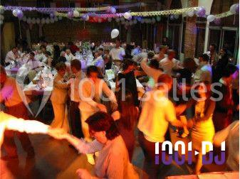 Personnes dansant et dînant dans une salle décorée pour une fête ou un événement festif.