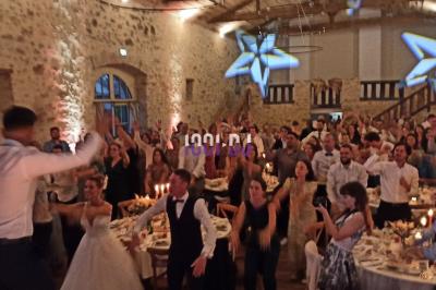 Salle de réception avec scène éclairée par des projecteurs orange, décorée de ballons suspendus.
