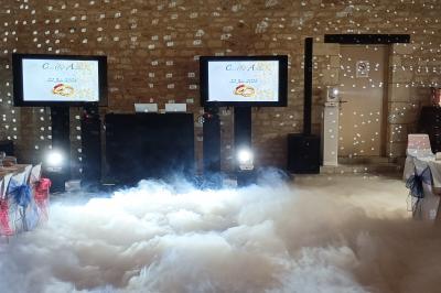 Salle de réception avec scène éclairée par des projecteurs orange, décorée de ballons suspendus.