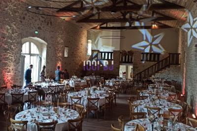 Salle décorée avec des lumières colorées, une table blanche au centre et un écran noir en arrière-plan.