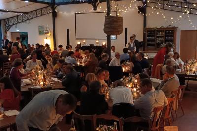 Salle décorée avec des lumières colorées, une table blanche au centre et un écran noir en arrière-plan.