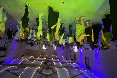 Salle décorée avec des lumières colorées, une table blanche au centre et un écran noir en arrière-plan.