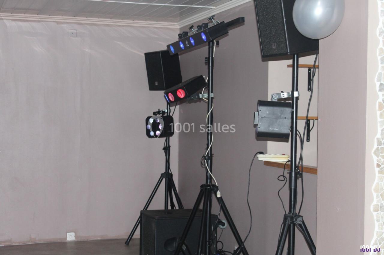 Équipement de sonorisation et d'éclairage installé dans une pièce avec murs clairs et ballon argenté.