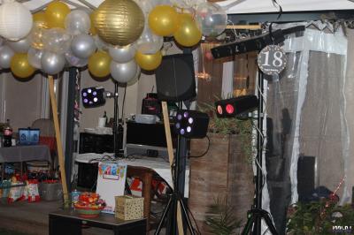 Équipement de sonorisation installé en extérieur sous une tente blanche, entouré de végétation.