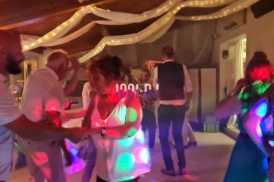 Équipement de sonorisation installé en extérieur sous une tente blanche, entouré de végétation.