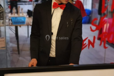 Salle de réception décorée avec des lumières violettes, tables dressées et écran affichant des prénoms.