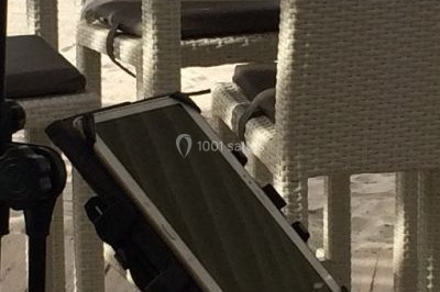 Salle de réception décorée avec des lumières violettes, tables dressées et écran affichant des prénoms.