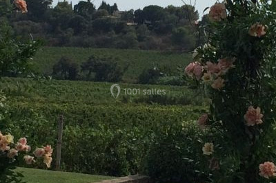 Salle de réception décorée avec des lumières violettes, tables dressées et écran affichant des prénoms.