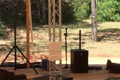 Salle de réception décorée avec des lumières violettes, tables dressées et écran affichant des prénoms.