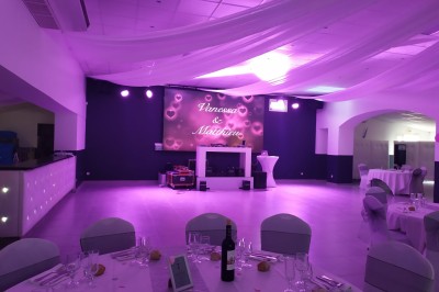 Des personnes entourent un couple célébrant avec des cierges magiques autour d'une table décorée avec un gâteau.