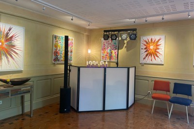 Des personnes entourent un couple célébrant avec des cierges magiques autour d'une table décorée avec un gâteau.