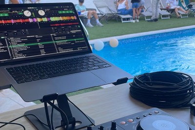 Des personnes entourent un couple célébrant avec des cierges magiques autour d'une table décorée avec un gâteau.