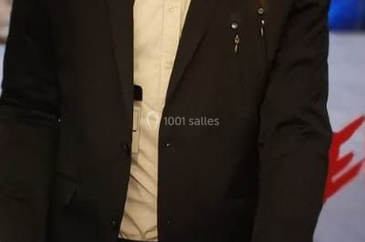 Salle de réception décorée avec des lumières violettes, tables dressées et écran affichant des prénoms.