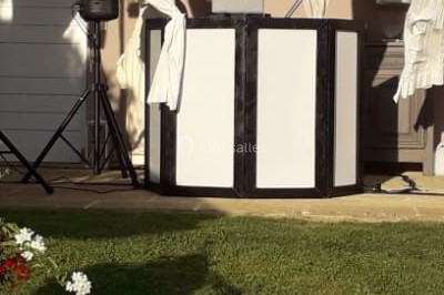 Salle de réception décorée avec des lumières violettes, tables dressées et écran affichant des prénoms.